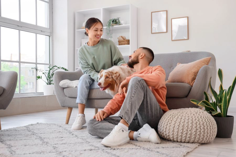 Young couple with Australian Shepherd dog resting at home 